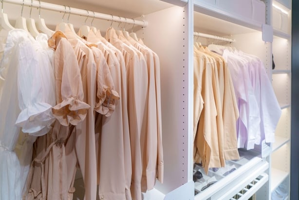 Stylish clothes hanging on a rail in wardrobe