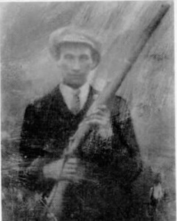 Black and white photo of man holding gun
