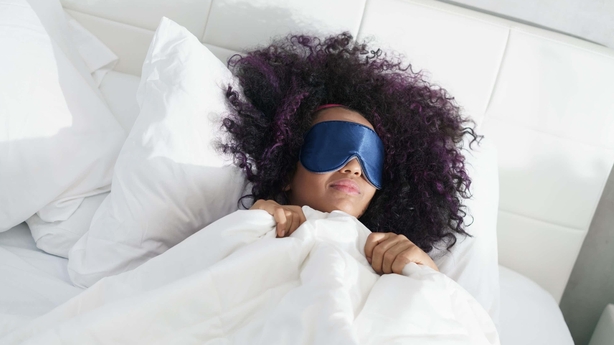 Woman in bed wearing a sleep mask