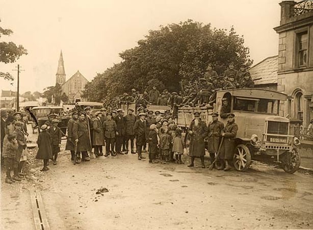 Children next to soliders in an armoured car