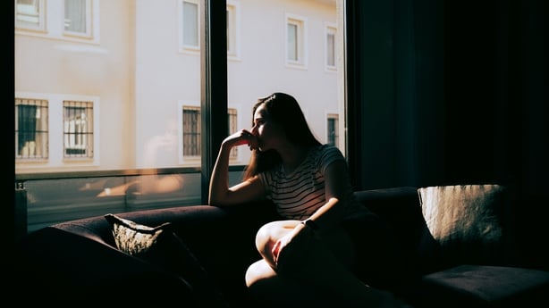 silhouette of a thoughtful sad woman with hand near her forehead