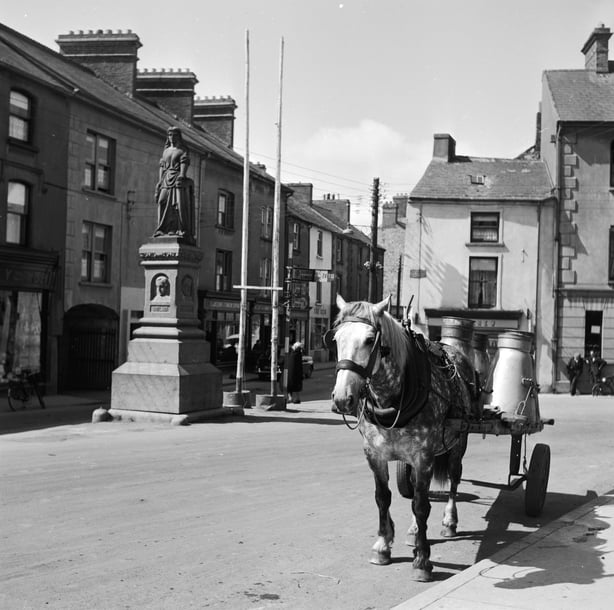 A horse drawn cart in a market squaree