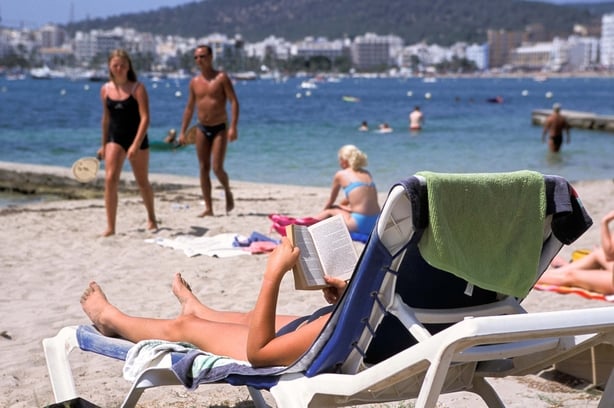 Sunbathing on the beach, San Antonio, Ibiza, Spain