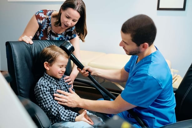 Paediatrician Doctor Doing Brain Treatment To Autistic Child In Clinic