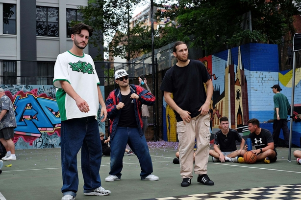 Three male dancers perform a breakdancing battle stand-off competitions and battles on the basketball courts of Woolloomooloo, Sydney