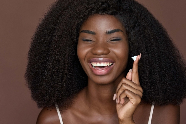 Woman applying moisturiser