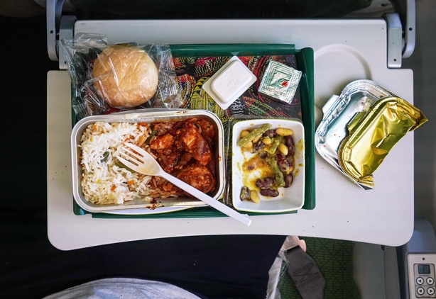 Airplane food, rice and chicken meat with beans salad, on tray table