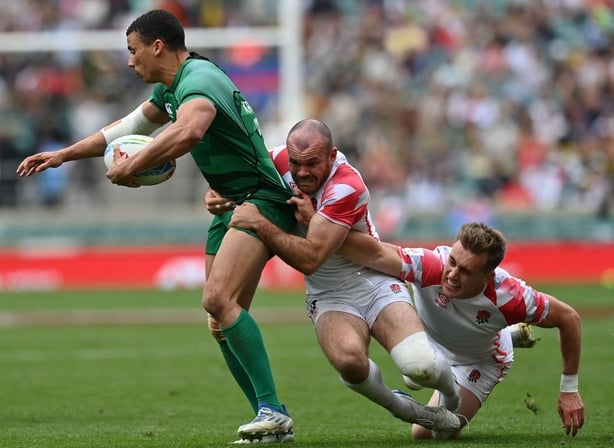 Ireland's Jordan Conroy (L) is tackled by England's Calum Randle (R) and England's Tom Bowen (C) during the rugby union match between Ireland and England on the second day of the London 2022 World Rugby Sevens Series event at Twickenham Stadium in west London on May 29, 2022. (Photo by Glyn KIRK / AFP) (Photo by GLYN KIRK/AFP via Getty Images)