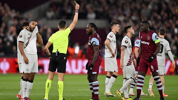 Referee Jose Sanchez shows a yellow card to both Michail Antonio of West Ham United and Jonathan Tah of Bayer Leverkusen