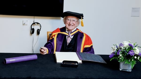 President Higgins signs the honorary degree register after a conferral ceremony in the University of Manchester