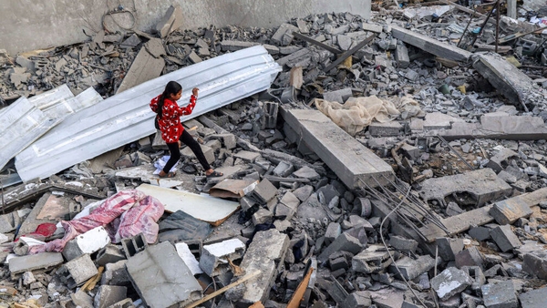 A girl walks through rubble after an Israeli air strike on Rafah