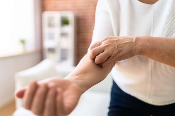 Woman itching her arm