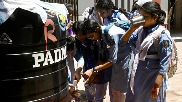 Students refill their water bottles at a school in Dhaka, Bangladesh, today