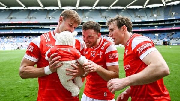 Conor Grimes (L) with his seven-week old daughter Izzy and team-mates Sam Mulroy (C) and Bevan Duffy