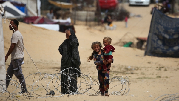Children walk in a camp for displaced people in Rafah in southern Gaza