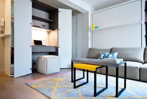 A hidden workspace within a mirrored wardrobe optimises space in this multifunctional room (Black & Milk/PA)