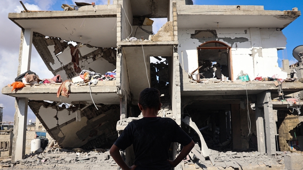 A boy stands in front of a destroyed building following Israeli bombardment of Rafah's Tal al-Sultan district
