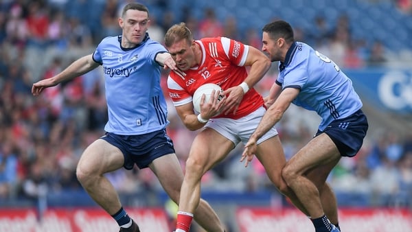 Conor Grimes of Louth is tackled by Brian Fenton and James McCarthy
