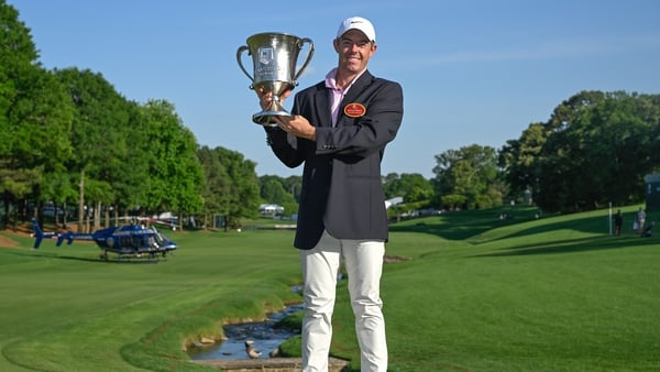 Rory McIlroy poses with his winner's trophy and Wells Fargo Championship jacket
