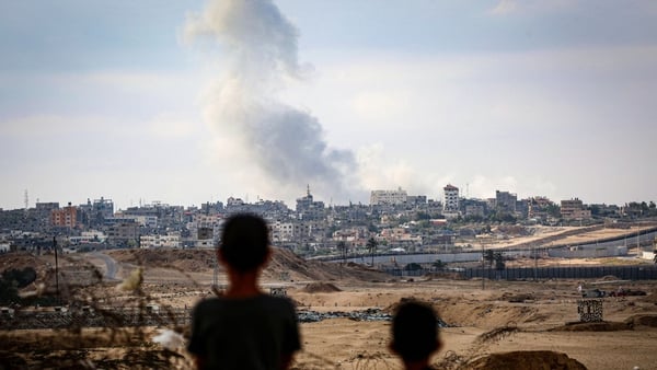 Boys watch smoke billowing during Israeli strikes east of Rafah