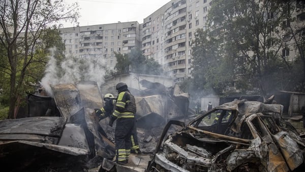 Firefighters pictured working to extinguish a fire at a residential area of Kharkiv following a Russian missile attack