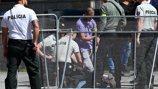 Security personnel pictured detaining the suspect gunman in the shooting of Robert Fico
