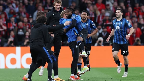 Ademola Lookman leaps into the arms of a member of the Atalanta backroom team after scoring the opening goal at the Aviva Stadium