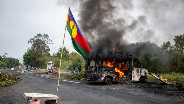 This photograph shows a Kanak flag waving next to a burning vehicle at an independantist roadblock at La Tamoa, in the commune of Paita, France's Pacific territory of New Caledonia on May 19, 2024. Photo: Getty Images