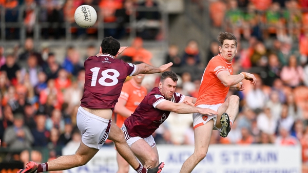 Armagh's Andrew Murnin kicks a point under pressure from Charlie Drumm (L) and Jamie Gonoud