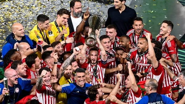 Olympiacos' players and staff celebrate with the trophy