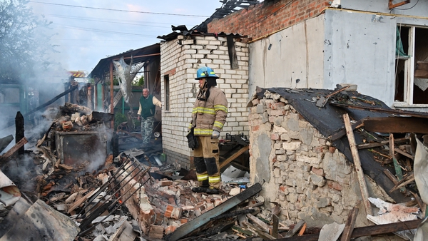 Firefighters clear debris from private houses in the suburbs of Kharkiv destroyed by the attack of Russian drones