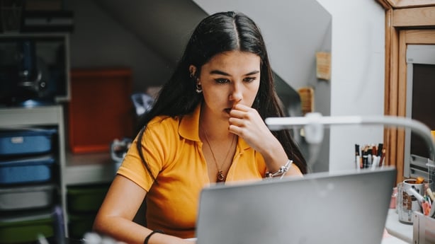 college student works on assignment in her dorm room