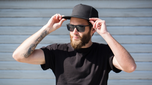 Hipster handsome male model with beard wearing black blank baseball cap 