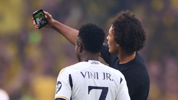 A pitch invader takes a selfie with Real Madrid's Vinicius Junior at Wembley