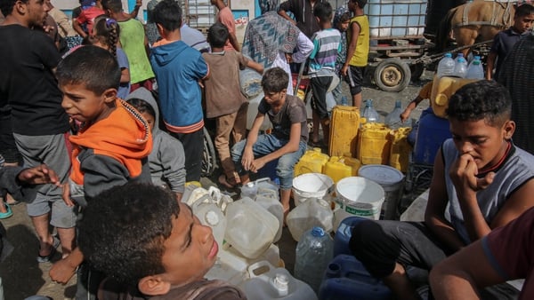 Displaced people wait to collect desalinated water in the Al Mawasi district of Khan Younis