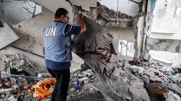 A UN worker inspects the damage at the school following the Israeli strike