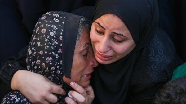 Palestinian women cry as dead bodies are brought to hospital in Deir Al Balah after Israel bombed an UNRWA school sheltering thousands of people