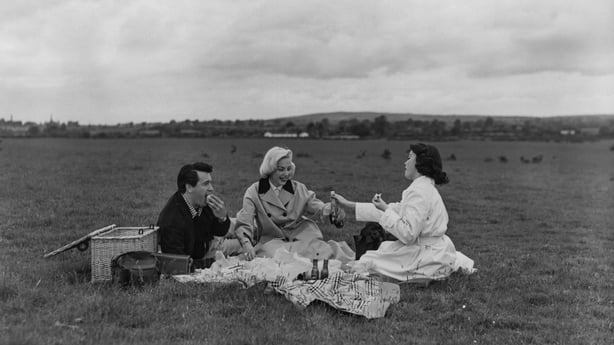 Rock Hudson (1925 - 1985) and Barbara Rush (right) having a picnic with script supervisor Betty Abbott (later Betty A. Griffin), on a stud farm owned by Prince Aly Khan, outside Dublin, Ireland, August 1954