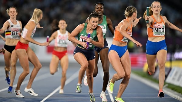 Phil Healy of Ireland takes the baton from team-mate Rhasidat Adeleke