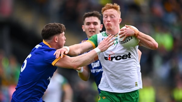 Donegal's Oisin Gallen is tackled by Cillian Rouine of Clare