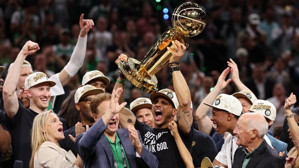 Boston Celtics head coach Joe Mazzulla hoists the Larry O'Brien Championship Trophy aloft at TD Garden