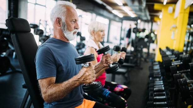 Happy fit mature man in gym working out to stay healthy