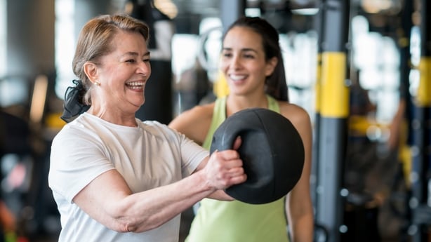 Adult woman exercising at the gym with a personal trainer