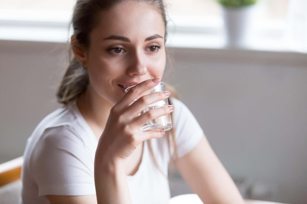 Dehydrated woman is drinking pure mineral water