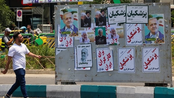 A man walks past posters in Tehran for this week's presidential election to replace Ebrahim Raisi, who was killed in a helicopter crash. Photo: Atta Kenare/AFP via Getty Images