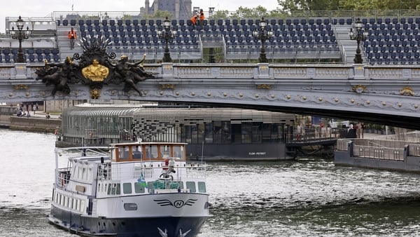 A boat cruises on the River Seine near the Alexandre III bridge where a grandstand is being built for the Paris 2024 Olympic Games opening ceremony