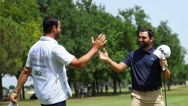 Antoine Rozner (R) shakes hands with his caddie on the 18th green