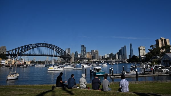 People take in the view of Sydney's landmarks, Harbour Bridge and Opera House