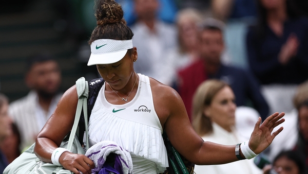 A dejected Naomi Osaka leaves the court