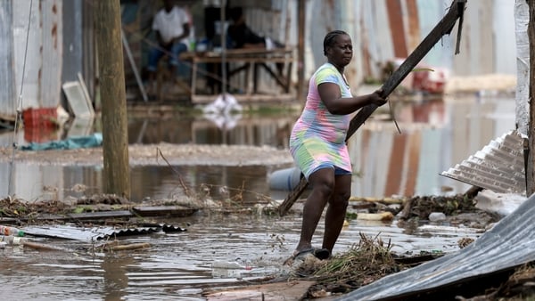 A woman gathers items from her home that were blown away as Hurricane Beryl passed through the area in Old Harbor, Jamaica